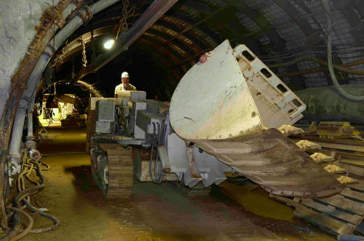 Ein Bergarbeiter mit Bagger im Stollen